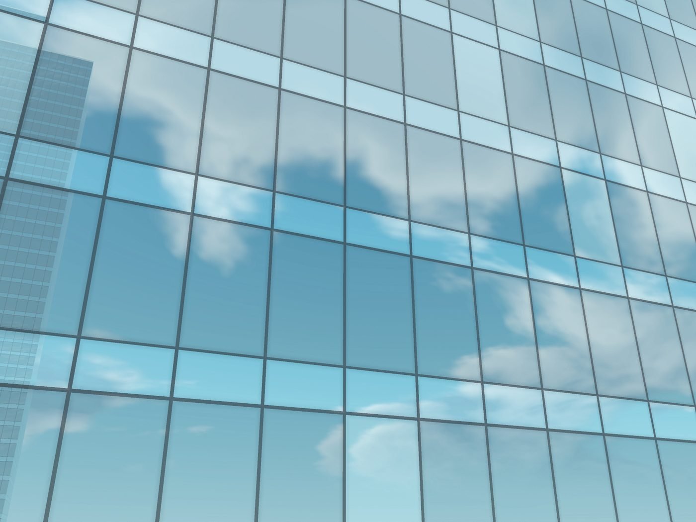 Glass curtain wall reflecting a blue sky